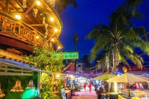 an outdoor market with palm trees and lights at night at Green Ocean Koh Rong in Koh Rong Island