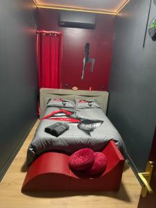 a bedroom with a bed with a red wall at Love&spa in Valras-Plage