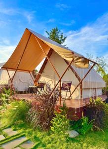 a tent with chairs and tables in a field at The Lake Farm - Dak Lak in Buon Ma Thuot