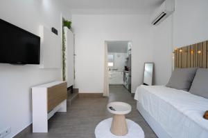 a white living room with a couch and a tv at Aréva - Provençal - Climatisé - Parking in Ventabren