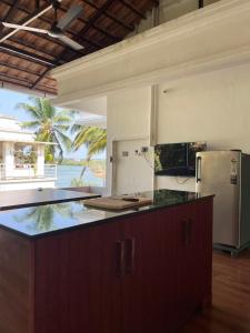 una cocina con encimera y refrigerador en Leela, en Green Island