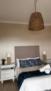 1 dormitorio con 1 cama y luz colgante en Point View Selfcatering, en Mossel Bay 4 fotos más