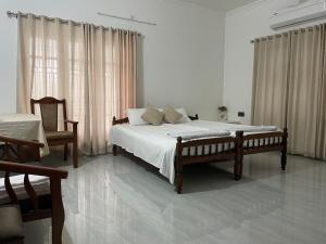 Un dormitorio con una cama grande y una silla en Leela, en Green Island