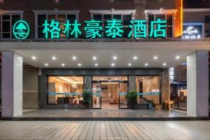 a building with a sign on the front of it at GreenTree Inn HanZhong Railway Station Beiyihuan Road Express Hotel in Shima