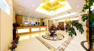 een lobby van een winkel met een klok aan het plafond bij GreenTree Inn Jiangsu Zhangjiagang Jingang Town Darunfa Express Hotel in Xiwujieqiao