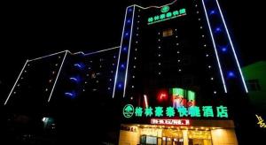 a large building with blue and green lights on it at GreenTree Inn Xinjiang Uygur Autonomous Region Korla Bazhou Bus Terminal Beishan Road Express Hotel in Bayingholin