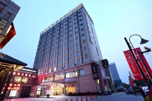 a tall building with a clock on top of it at GreenTree Inn Shanghai Jiading Newtown MaLu Subway Station Business Hotel in Jiading