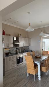 Una cocina con una mesa y sillas en una cocina. en Point View Selfcatering, en Mossel Bay