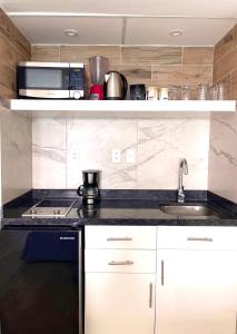 une cuisine avec un évier et un micro-ondes dans l'établissement Beachside Apartments Cancun, à Cancún