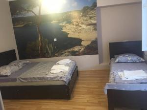 2 Betten in einem Zimmer mit Wandgemälde in der Unterkunft Hotel Prime in Mzcheta