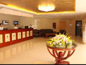 a lobby with a waiting room with flowers on a table at GreenTree Inn Jiangsu Xuzhou Jinshan Bridge Building Jinqiao Road Express Hotel in Xuzhou