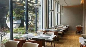 een rij tafels en stoelen in een restaurant bij Zhangjiagang Jiangnan Garden Hotel in Xiwujieqiao