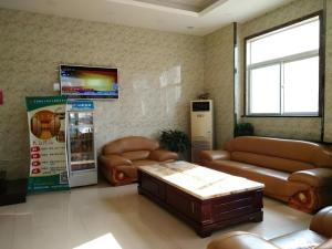 a living room with leather couches and a soda machine at Shell Hotel Taiyuan South Railway Station New Southeast Bus Station in Taiyuan