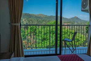 Una habitación con balcón con silla y vista. en Hotel Woodlark, en Kattappana