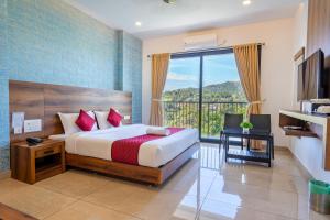 a bedroom with a bed and a large window at Hotel Woodlark in Kattappana