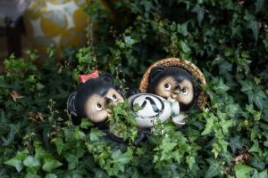 two dolls are sitting in the bushes at Kanazawa 旅音 in Kanazawa