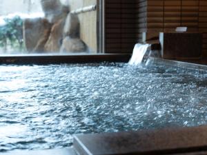 a pool of water with a waterfall at GLOBAL RESORT NUKUI in Akiota