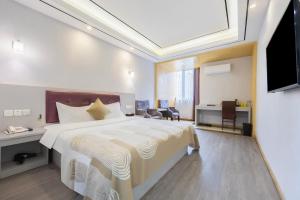 a hotel room with a large bed and a television at Huayi Hotel in Shanghai
