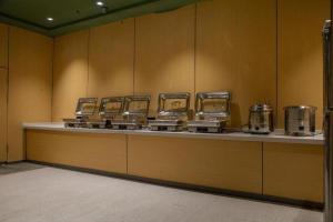 a kitchen with a row of counters with pots and pans at GreenTree Inn Anhui Bozhou West Guangming Road Tangwang Avenue Shall Hotel in Bozhou