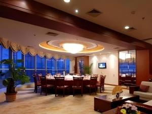 a dining room with a table and chairs and windows at Lu'an Jinling Wanxi Hotel in Lu'an