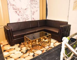 un sofá de cuero marrón con una mesa de centro de cristal en Hotel Aroma Inn, en Morādābād