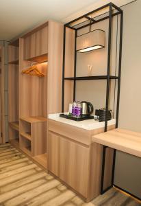 Una cocina con gabinetes de madera y encimera. en Hotel Aroma Inn, en Morādābād