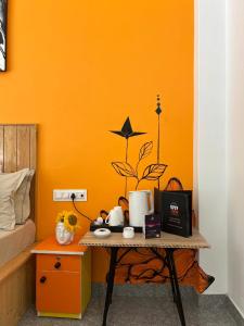 ein kleiner Tisch in einem Schlafzimmer mit einer orangefarbenen Wand in der Unterkunft Himtrek Stays Katagala in Kasol + 41 Fotos