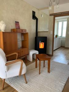 ein Wohnzimmer mit Kamin und Sessel in der Unterkunft Charmante maison du vieux Coutainville, à 15mn à pied de la mer, classée 3 étoiles in Agon Coutainville
