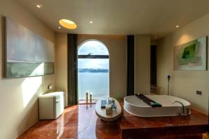 a large bathroom with a tub and a large window at Shanheli Mediterranean Seaside Resort Homestay East Coast Branch in Ma Yu +48 photos
