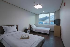 a hotel room with a bed and a television at Pyeongchang the white view in Pyeongchang 