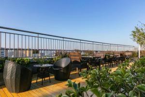 a deck with tables and chairs on a balcony at SSAW Boutique Hotel Shaoxing Ancient Town in Dongpu
