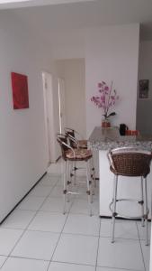 a room with chairs and a counter with a table at Residencial André Reis in Fortaleza