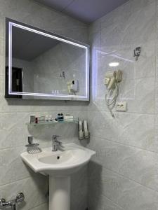 a bathroom with a sink and a mirror at Reikartz Grand Kokand in Kokand