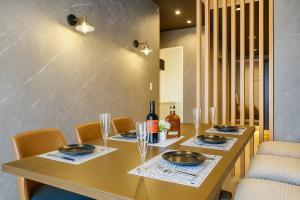 een eetkamer met een tafel met stoelen en wijnflessen bij 今宵の宿 中州庵 in Fukuoka +12 foto's