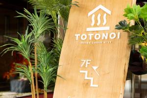 a wooden sign for a tokyo shop with plants at Ooedo Onsen Monogatari Premium Yoshinoya Irokuen in Kaga