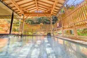an empty swimming pool in a pavilion with a wooden ceiling at Ooedo Onsen Monogatari Premium Yoshinoya Irokuen in Kaga