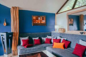 a living room with a green couch with red pillows at BambooJam Villa in La Ceiba