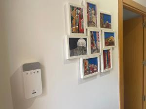 eine Wand mit gerahmten Bildern an einer Wand in der Unterkunft Encanto cuenca puerta al silencio in Cuenca + 7 Fotos