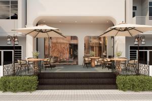 a patio with tables and chairs and umbrellas at HAITA Suites in Ho Chi Minh City