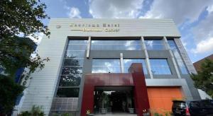 a building with a sign on the front of it at Kharisma Hotel in Madiun