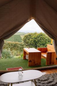 a tent with a table and a view of a field at Danny Glamping Farm in Bao Loc