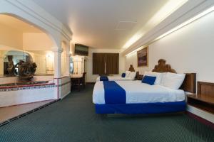 a hotel room with a large bed and a kitchen at Colony Inn in North Hollywood +42 photos
