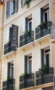 una fachada de un hotel con balcones y plantas en Hotel l'Hotera en Cannes