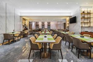a restaurant with tables and chairs in a room at Dandong Xin An Dong Hotel in Dandong