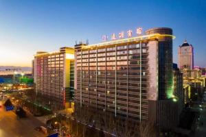 een groot gebouw met een bord erop bij Tangshan Qiangang Hotel in Qian'an