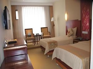 een hotelkamer met twee bedden en een tafel bij Wutaishan Wufeng Hotel in Wutai