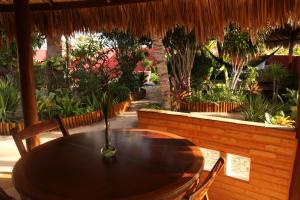 a wooden table and chairs in a garden at Pousada Villa Botânica in Aracati