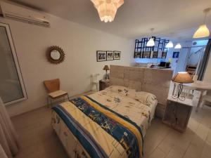 una camera da letto con un letto, un tavolo e uno specchio di Loft marsa cube vue panoramique vue mer a La Marsa