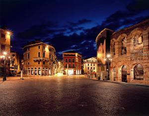 una calle de ciudad vacía por la noche con edificios en Escalus Luxury Suites Verona, en Verona