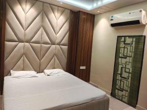 a bedroom with a bed and a large headboard at Hotel O THE ERA INFINITY HOTEL in Faithfulganj